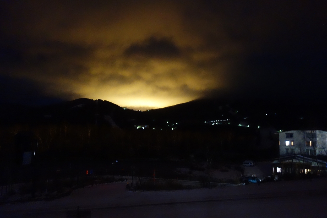 事務所から高天ヶ原方面を望む。スキー場整備のための照明が雲に反射している。
